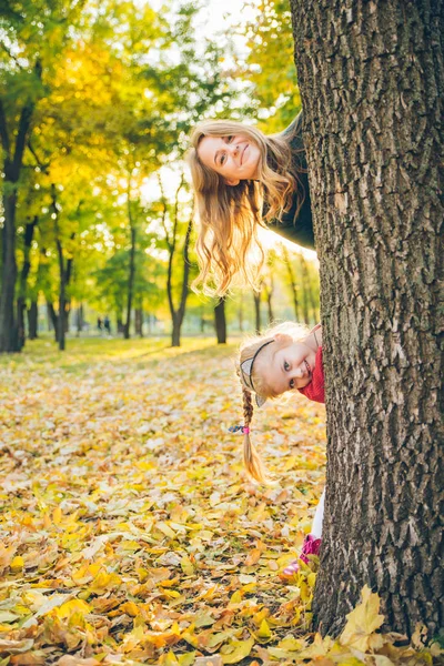 Mãe com filha espreita para fora da árvore — Fotografia de Stock