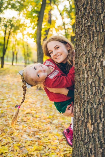 딸을 안고 있는 엄마가 나무 위에서 징징 거린다 — 스톡 사진