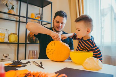 Küçük oğlu olan genç baba Cadılar Bayramı 'nda balkabağı başı yapıyor.