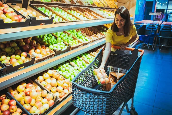 Junge hübsche erwachsene Frau beim Einkaufen im Lebensmittelgeschäft Apfel kaufen — Stockfoto