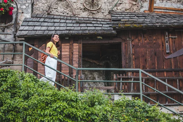 Mladá, velmi usměvavá turistická žena, která chodí po schodech malého Hallstattu — Stock fotografie