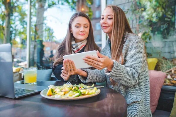 Två unga vuxna kvinnor har möte i Outdoors café som arbetar på laptop — Stockfoto