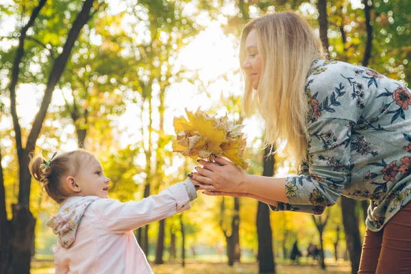Mała dziewczynka bawiąc się z liści klonu wieniec — Zdjęcie stockowe