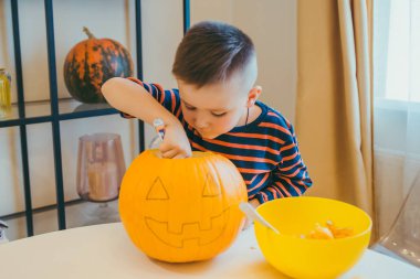 küçük çocuk evde halloween kabak kafa yapar