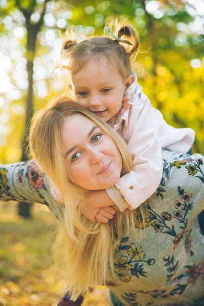 Huckepack-Mutter spielt mit Tochter im Stadtpark — Stockfoto