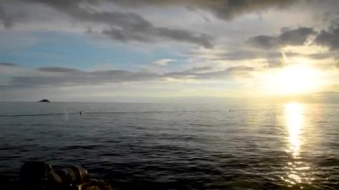 Hırvatistan'ın rovinj şehrinde gün batımı nın manzarası kayalıklarda oturup manzaranın tadını çıkarıyorlar. yaz saati