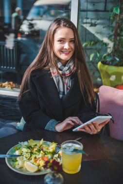 tablet kullanarak açık hava kafede genç güzel zerafet kadın