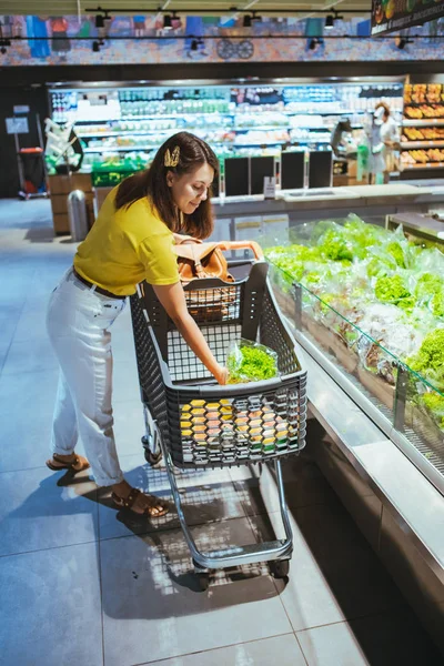 Mujer tomando ensalada de la tienda de comestibles estante —  Fotos de Stock