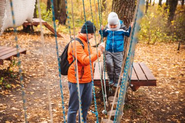 oyun alanı sonbahar sezonunda oynayan küçük çocuk oğlu ile baba
