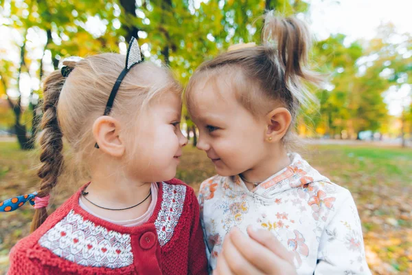 Duas meninas brincando no outono parque da cidade — Fotografia de Stock