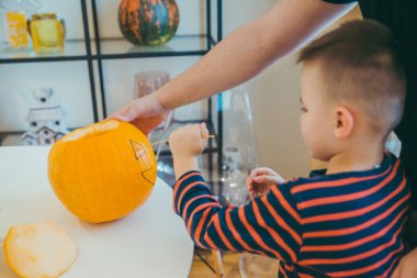 Küçük oğlu olan genç baba Cadılar Bayramı 'nda balkabağı başı yapıyor.