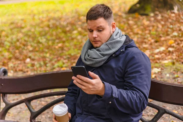 Man drinking coffee outdoors autumn season talking on the phone — Stock Photo, Image