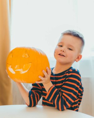 küçük çocuk evde halloween kabak kafa yapar