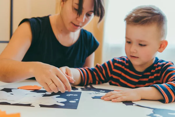 Young mother with toddler son making craft spiders for halloween holiday — Stock Photo, Image