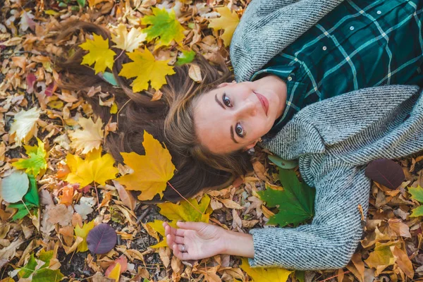 Mulher deitada no chão no outono folhas amarelas — Fotografia de Stock