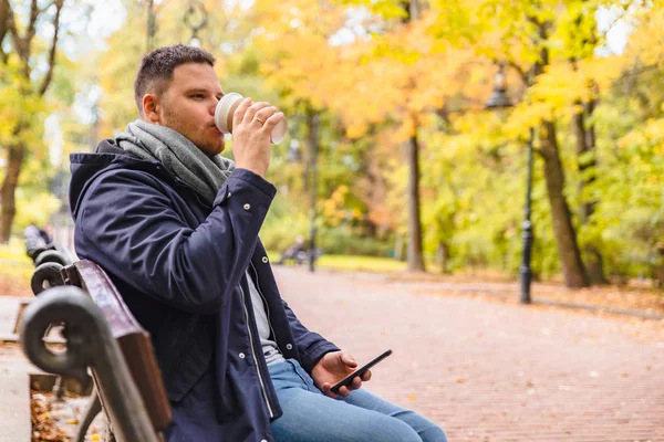 Man drinking coffee outdoors autumn season talking on the phone — Stock Photo, Image