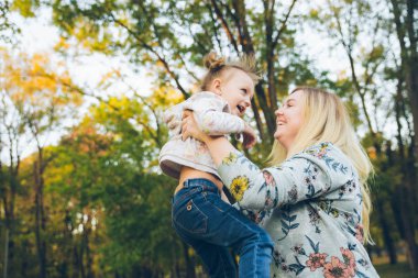Mather ve küçük kızı sonbahar parkında oynuyorlar.
