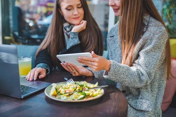 Duas mulheres adultas jovens têm reunião no café ao ar livre trabalhando no laptop — Fotografia de Stock