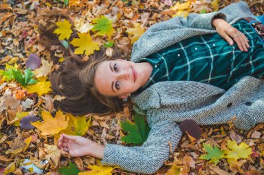 woman laying on the ground in autumn yellow leaves