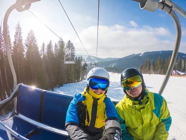 Casal tomando selfie em equipamento de esqui enquanto levantar para colina — Fotografia de Stock