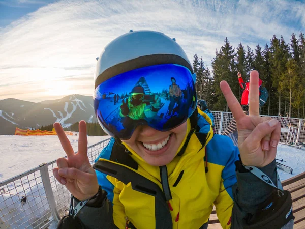 Amigos se divierten tomando fotos en la cima de la colina nevada. reflexión en gafas. esquí y snowboard —  Fotos de Stock