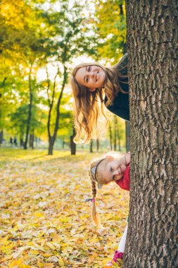 Anne ve kızı ağaçtan dikizliyorlar.