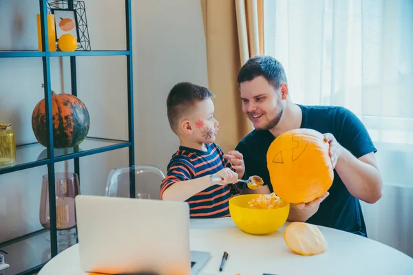 Young father with toddler son making jack pumpkin head for halloween holiday — Stock Photo, Image