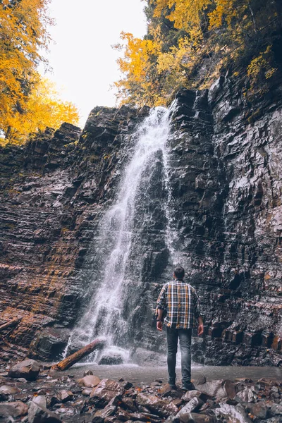 Caminhante homem olhando para cachoeira outono — Fotografia de Stock