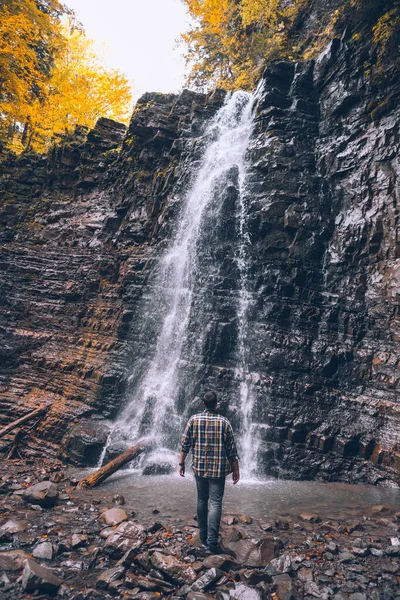 Wandelaar kijken naar de herfst waterval — Stockfoto