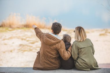 genç güzel aile görünümü göl ile plajda oturan