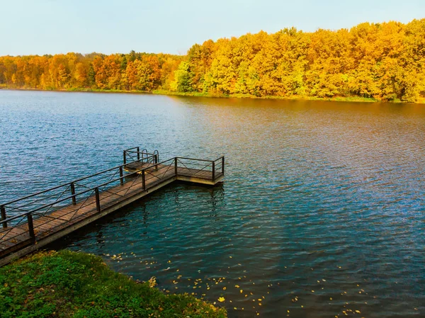 Пирс на озере с видом на осенний лес — стоковое фото