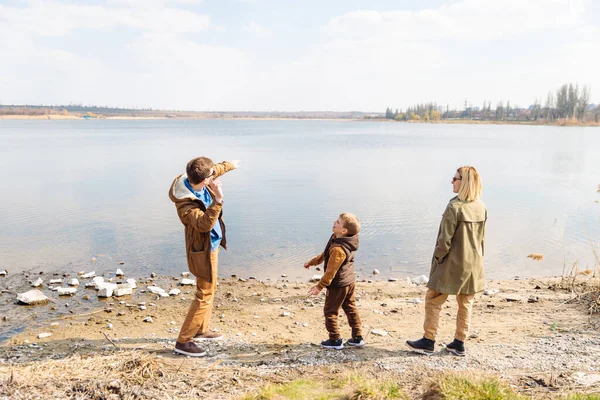 Father teaching little son throw rocks in water — Stock Photo, Image