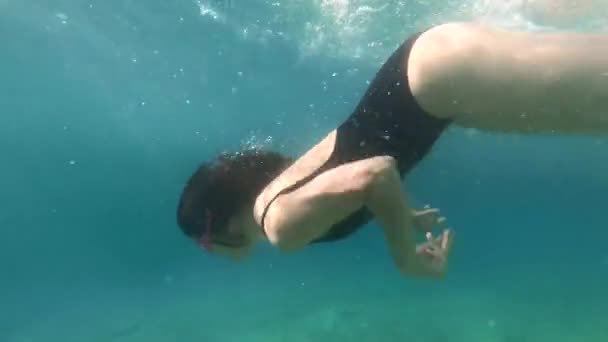 Frau schwimmt mit Maske unter Wasser und sucht Muscheln — Stockvideo