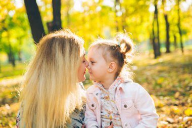 Mather ve küçük kızı sonbahar parkında oynuyorlar.