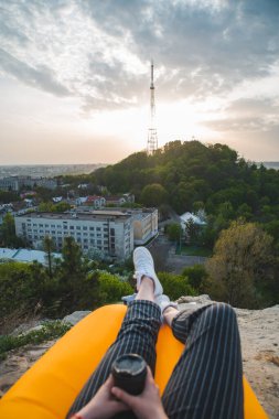 Kadın şehrin üzerinde gün batımına bakıyor..