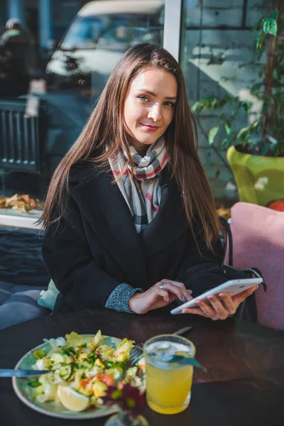 Mujer joven bastante elegancia en la cafetería al aire libre utilizando tableta — Foto de Stock