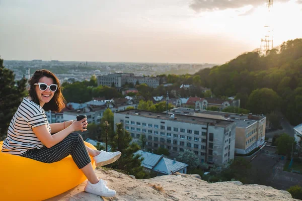 Žena pije kávu s krásným výhledem na západ slunce nad městem Iviv v ukrajinském — Stock fotografie