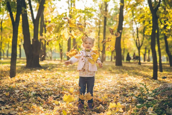 Mather con pequeña hija tocando en el parque público de otoño de la ciudad — Foto de Stock