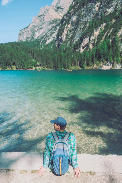 Homme avec sac à dos regardant le lac dans les montagnes de dolomites — Photo