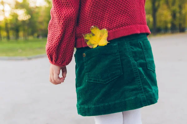 Κοριτσάκι στο πάρκο της πόλης κίτρινο φύλλο σφενδάμου σε ακούσει πίσω τσέπη — Φωτογραφία Αρχείου