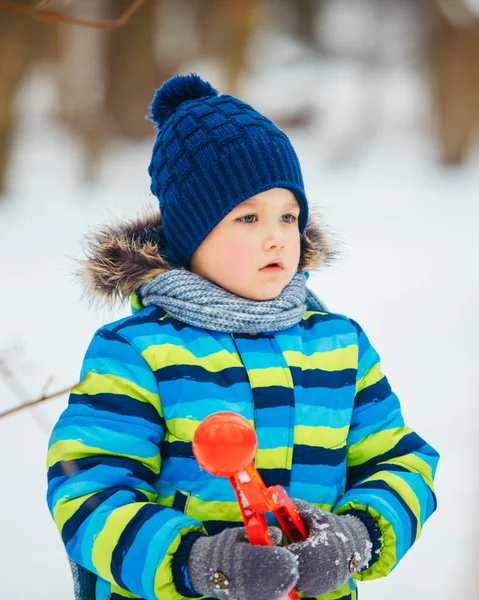 Lindo niño con bola de nieve fabricante en las manos —  Fotos de Stock