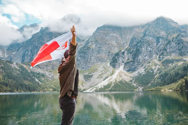 폴란드 국기를 두른 사람 은산 속에 있는 호수를 바라보면서 가장자리에서 서 있다 — 스톡 사진