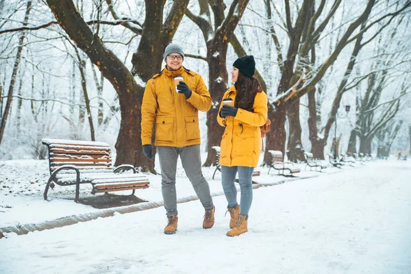 Casal andando pelo parque da cidade nevada falando socialização. data romântica no tempo de inverno — Fotografia de Stock