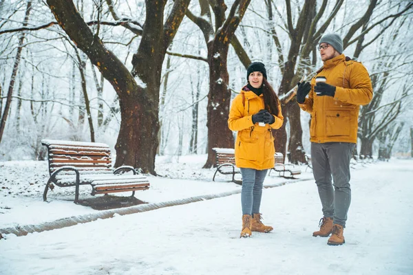 Pareja caminando por el parque de la ciudad nevada hablando socializando. cita romántica en invierno — Foto de Stock