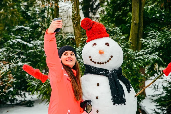 Mooie vrouw het nemen van selfie met sneeuwpop — Stockfoto