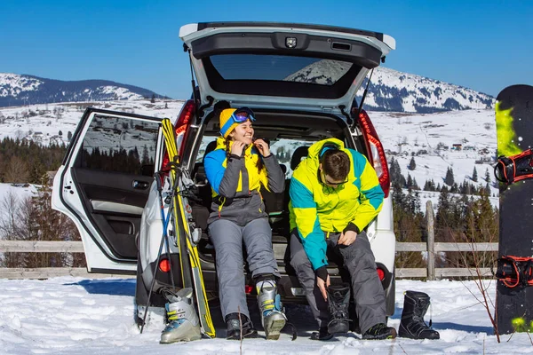 Kadın ve erkek arazi aracı yakınlarında kayak malzemesi giyiyorlar. — Stok fotoğraf
