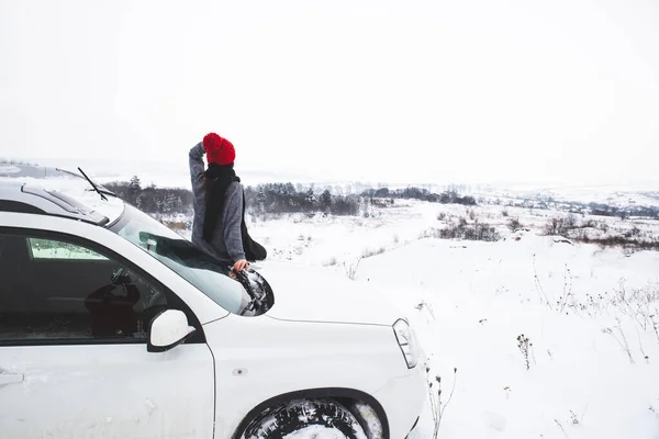 Mujer sentada en la capucha de coche suv con hermoso paisaje — Foto de Stock