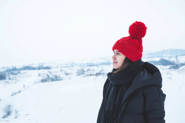Giovane donna adulta in abiti invernali con cappello rosso brillante all'aperto — Foto Stock