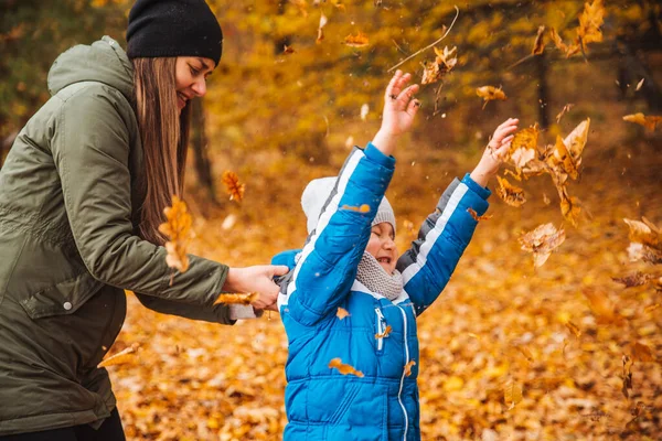 Madre con hijo jugando al aire libre en el parque de otoño de la ciudad —  Fotos de Stock