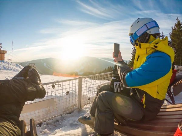 Homem com mulher descansando no topo da colina nevada bebendo bebidas de aquecimento — Fotografia de Stock